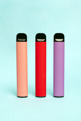 Set of colorful disposable electronic cigarettes on a light texture background. The concept of modern smoking, vaping and nicotine. Top view
