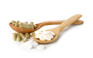 Spoons with pills on white background