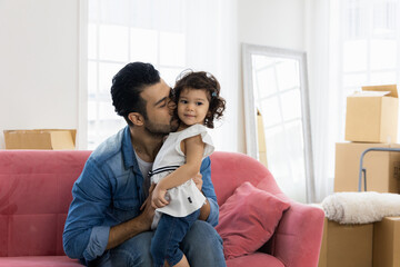 Obraz premium Happy family moment in the house. Father and daughter relaxing on red sofa. The family just moving in new house.
