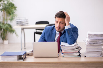 Young male employee and too much work in the office