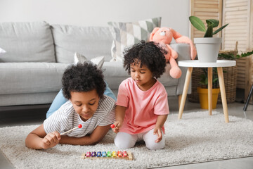 African-American children playing with xylophone at home