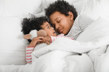 African-American children lying in bed