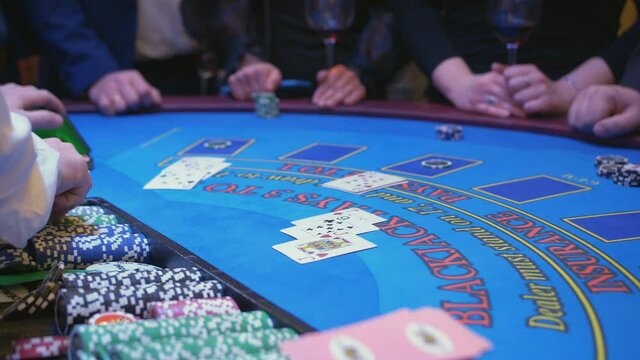 A large gaming table table in a casino. Men and women at the casino gaming table place bets with playing chips.