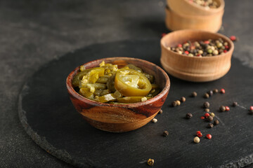 Bowl with canned jalapeno on dark background