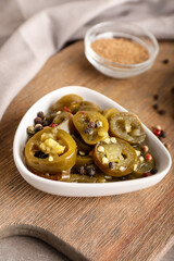 Bowl with canned jalapeno on table, closeup