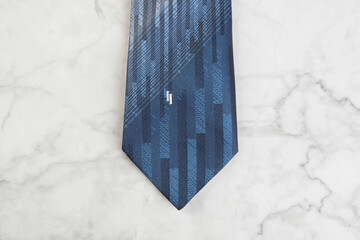 Blue tie on marble background.