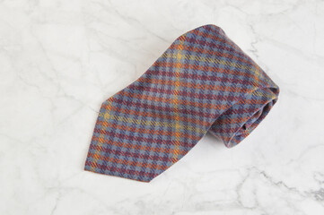 Checkered neck tie on marble background.