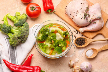 Stylish cooking pot with tasty soup and ingredients on light background