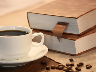 The concept of teaching education with the opening of a book or textbook in the library. a cup of fresh coffee on the table.