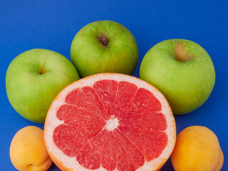Fresh organic fruit on a blue background, space to copy.