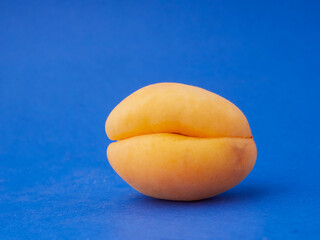Close up view of an apricot with blue background