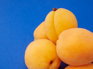 Close up view of an apricot with blue background