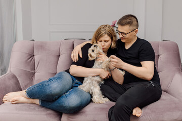 Portrait of young couple with Yorkshire Terrier dog exudes love and tenderness . Happiness of being...