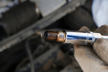 The mechanic performs diagnostics of the car engine. Inspection of the spark plug. Traces of oil on...