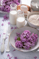 Obraz na płótnie Canvas Tasty fried lilac flower with powdered sugar. Sweet snack.