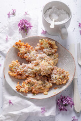 Tasty fried lilac flower with powdered sugar. Summer snack.