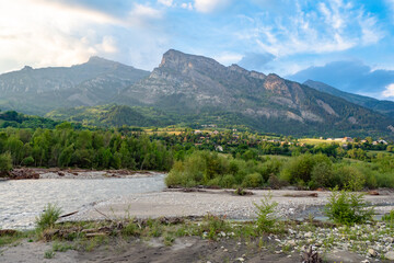 Springtime scenic view of the mountains in the Alps with emerging plant life and diminishing snow capped peaks