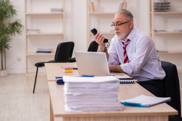 Obraz premium Old businessman employee sitting in the office