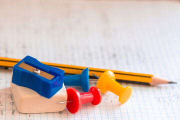 notebook, eraser, pencil sharpener, pencil and thumbtacks, back to school concept