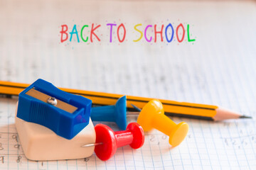 back to school concept. notebook, eraser, pencil sharpener, pencil and thumbtacks,