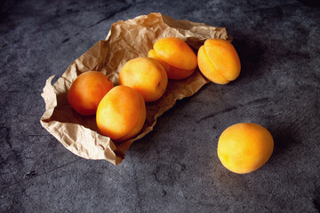 Apricots in Kraft paper on a black table