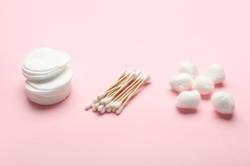 Cotton swabs, pads and balls on color background