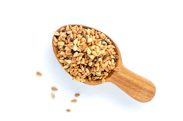 Top view of dry organic roasted white and black sesame seed pile in wooden spoon on white background