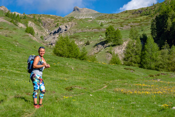 Naklejka na ściany i meble Female hiker climbing the alps while on photography and camping trip