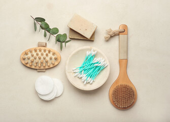 Fototapeta na wymiar Composition with cotton swabs, comb, brush, soap and buds on light background