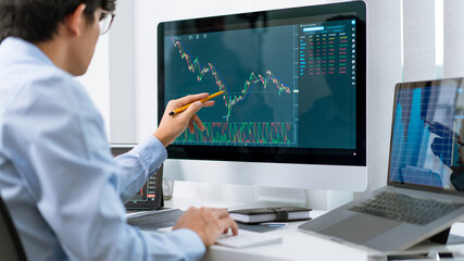 Fototapeta premium Financial concept a businessman studying the stock chart analyzing the growths of the stock from the chart before investment.