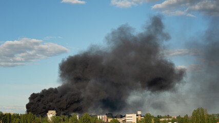 Fototapeta premium Burning building with black smoke. Huge smoke clouds after explosion