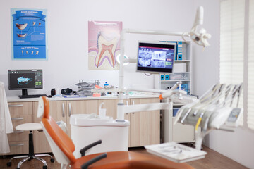 Modern orange dentist cabinet with sterile utensils. Stomatology cabinet with nobody in it and orange equipment for oral treatment.