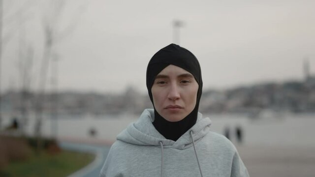 Healthy muslim woman in hijab running ner city river