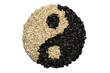 Sunflower seeds in a peel and peeled seeds in the form of yin-yang.
