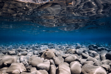 Underwater sea with stones, reflection and crystal water.