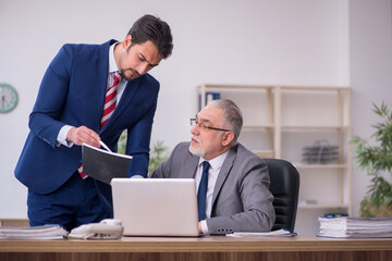 Two male employees working in the office