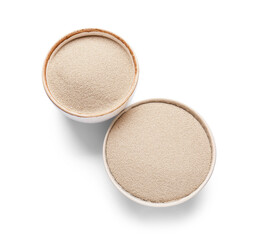 Bowls with active dry yeast on white background