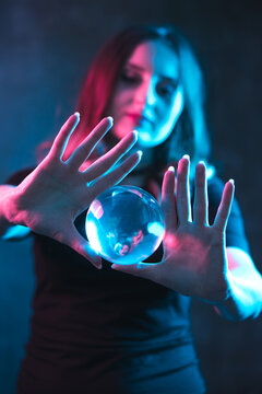 Fortune telling and forecasting future concept. Girl in colorful neon lighting shows trick.
