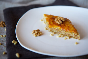 Close-up dessert is a piece of cake with walnuts, honey and pine nuts.