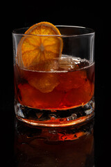 Alcoholic cocktail Old fashioned cocktail with orange slice and lump sugar on black background. Copyspace