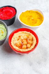 Traditional Middle eastern food various hummus. Green,yellow,beet and traditional hummus in small bowls.