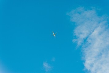 A plane is flying in the blue sky