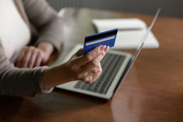 Crop close up of old Caucasian female buyer shopping online on laptop with credit debit card. Mature modern woman client make payment buy on web on computer with secure banking application on device. - Powered by Adobe