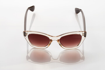 Sunglasses on a white reflective surface. Fashionable, stylish accessories.  Use it for a vacation...