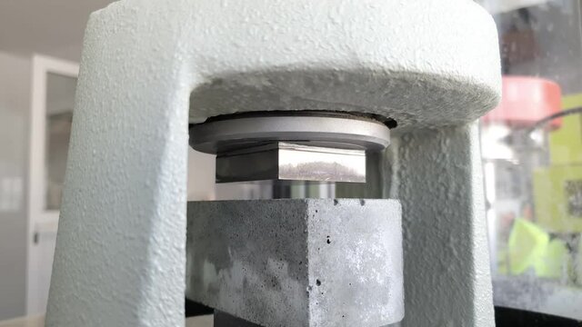 Compressive strength test on cube of concrete, engineering material property of composite and cement concrete are testing in physics laboratory. Selective focus