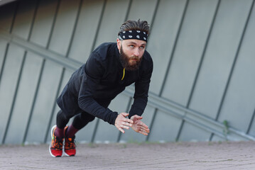 Sports man doing push ups with claps during outdoors training.