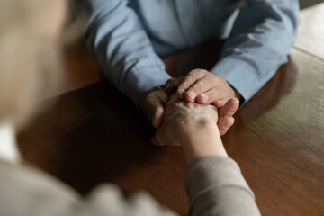 Old Caucasian man hold senior wife hand comfort and caress make peace reconcile after fight. Supportive middle-aged husband touch show love and care to mature woman spouse. Unity concept.