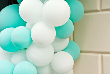The entrance to the store is decorated with colorful balls. White and green balloons close up.
