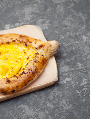 Georgian food. Georgian khachapuri on stone background. Georgian pie filled with cheese