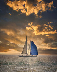 Un velero navegando ante un atardecer
